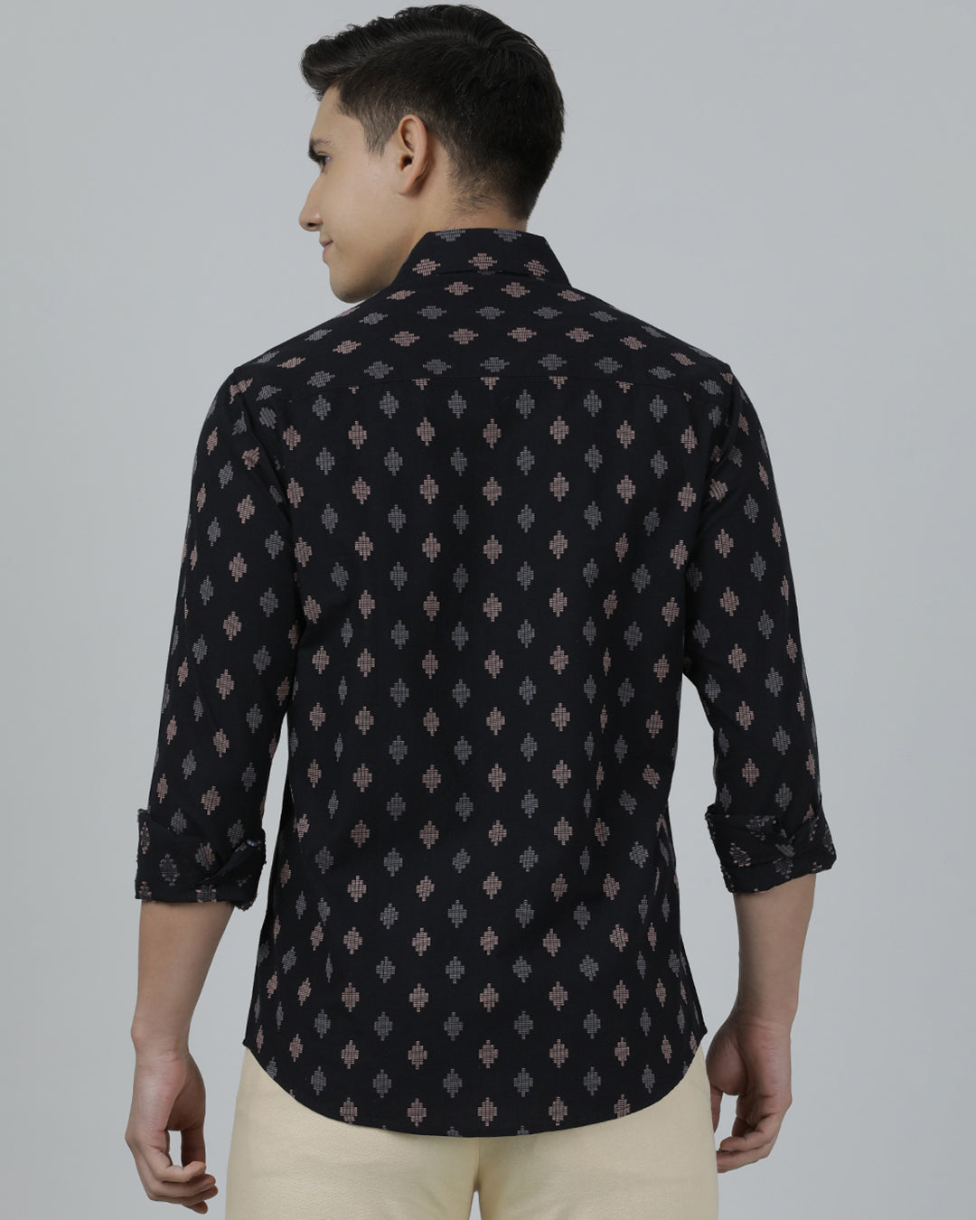 Man wearing a black black printed full sleeve shirt on a light gray background