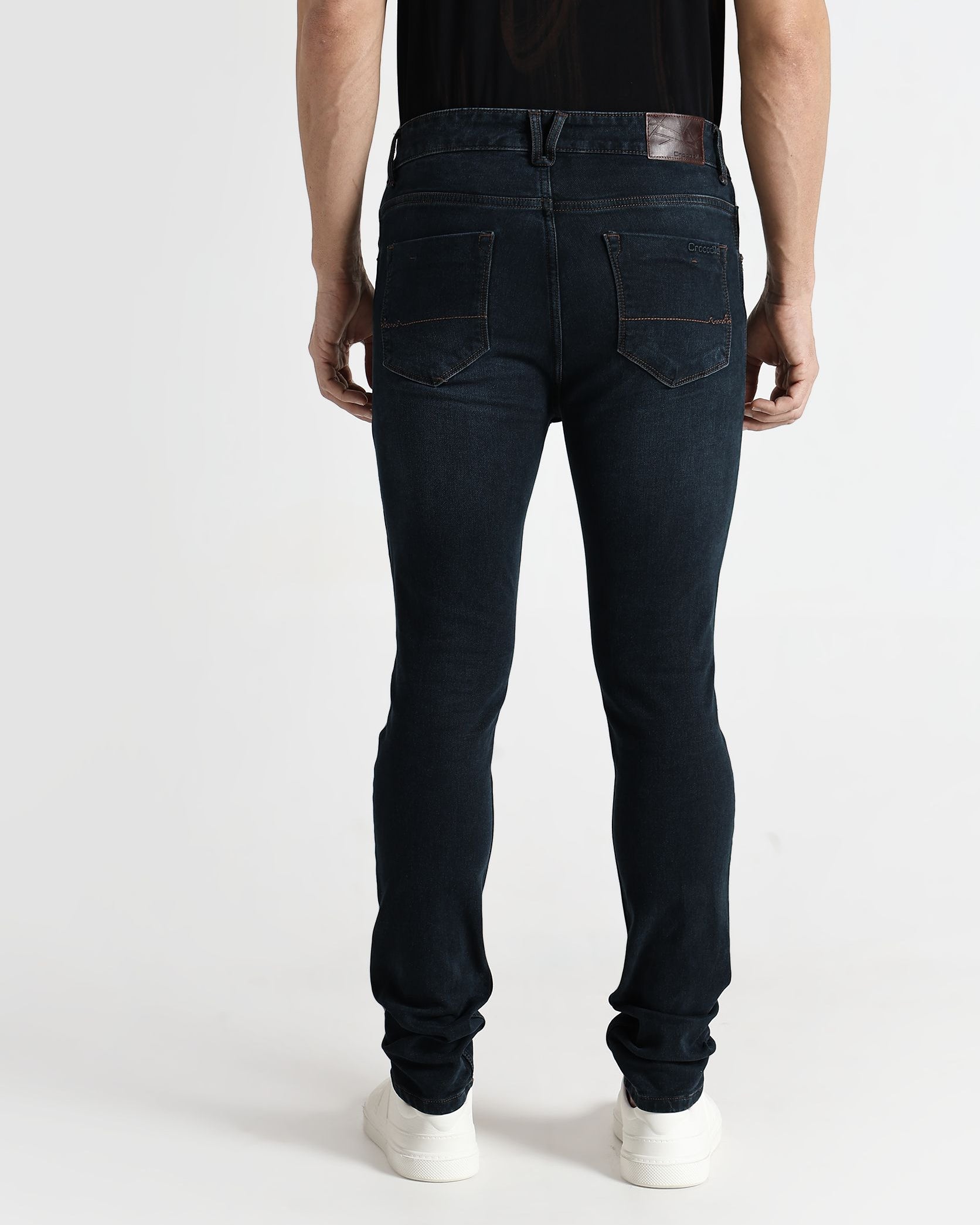 Person wearing dark blue jeans and a black shirt on a white background