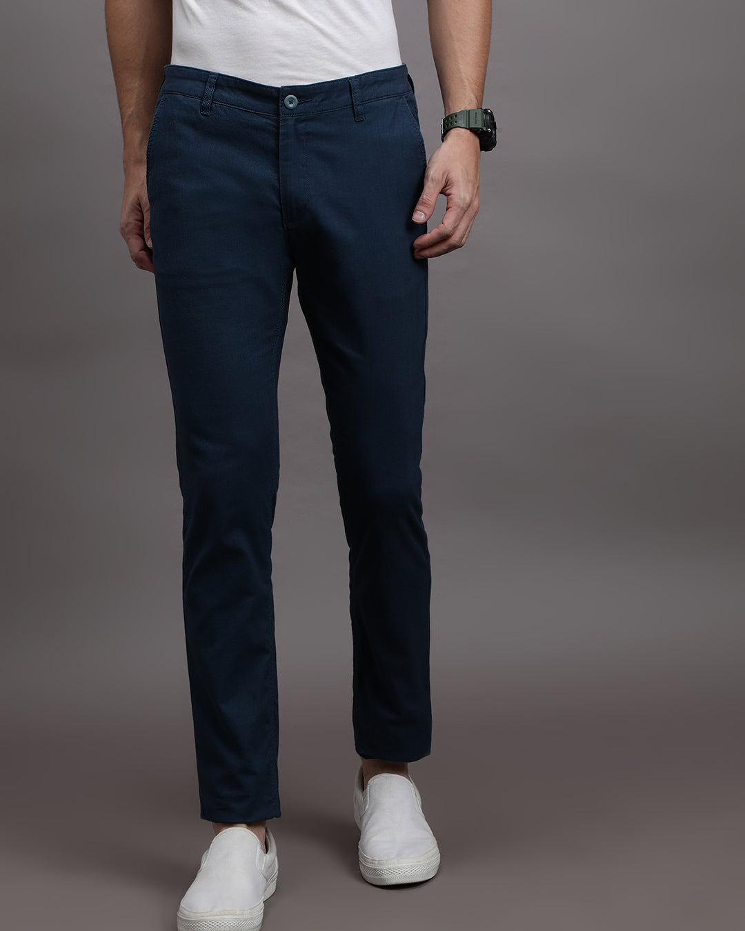 Man wearing a navy solid slim fit casual navy trouser on a light gray background