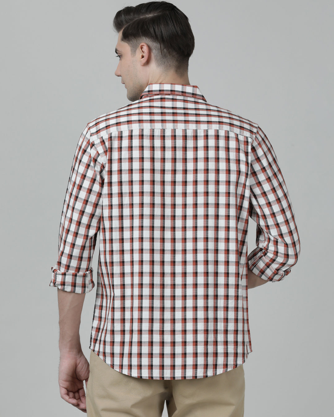 Man wearing a red brick red checked full sleeve 100% cotton shirt on a light gray background