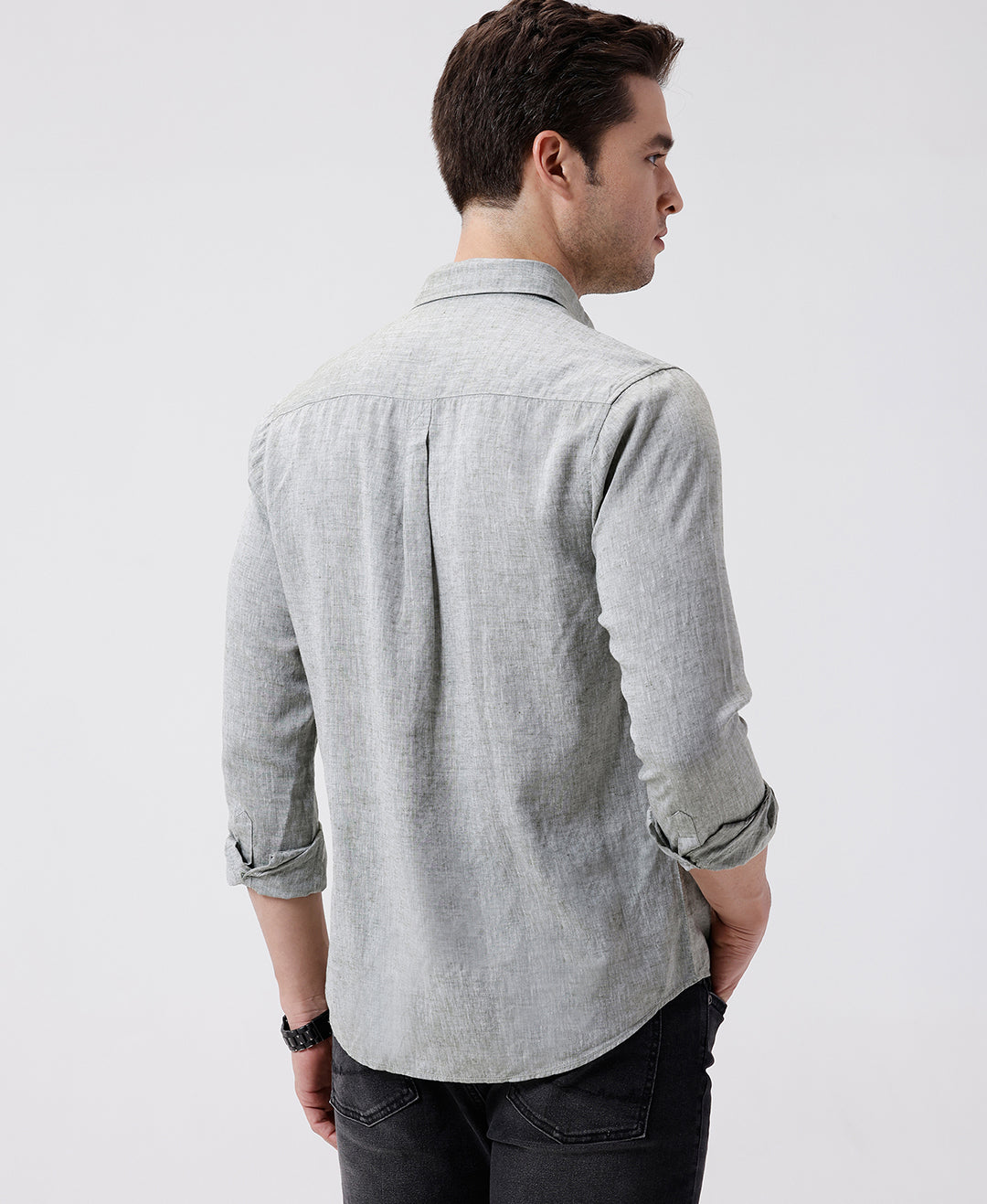 Man wearing a green premium tensil linen shirt dark green on a light gray background