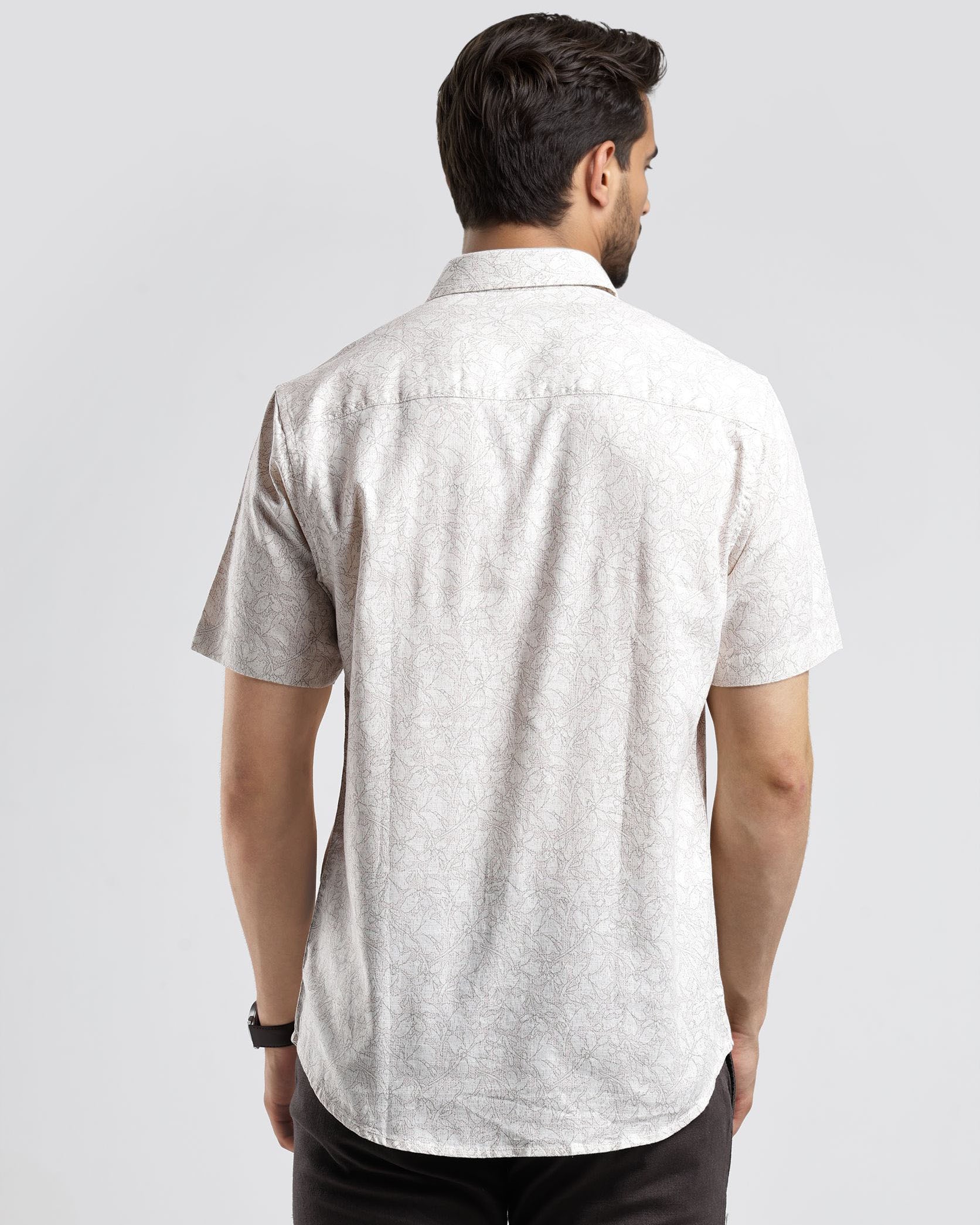 Man wearing a light gray short-sleeve shirt on a white background