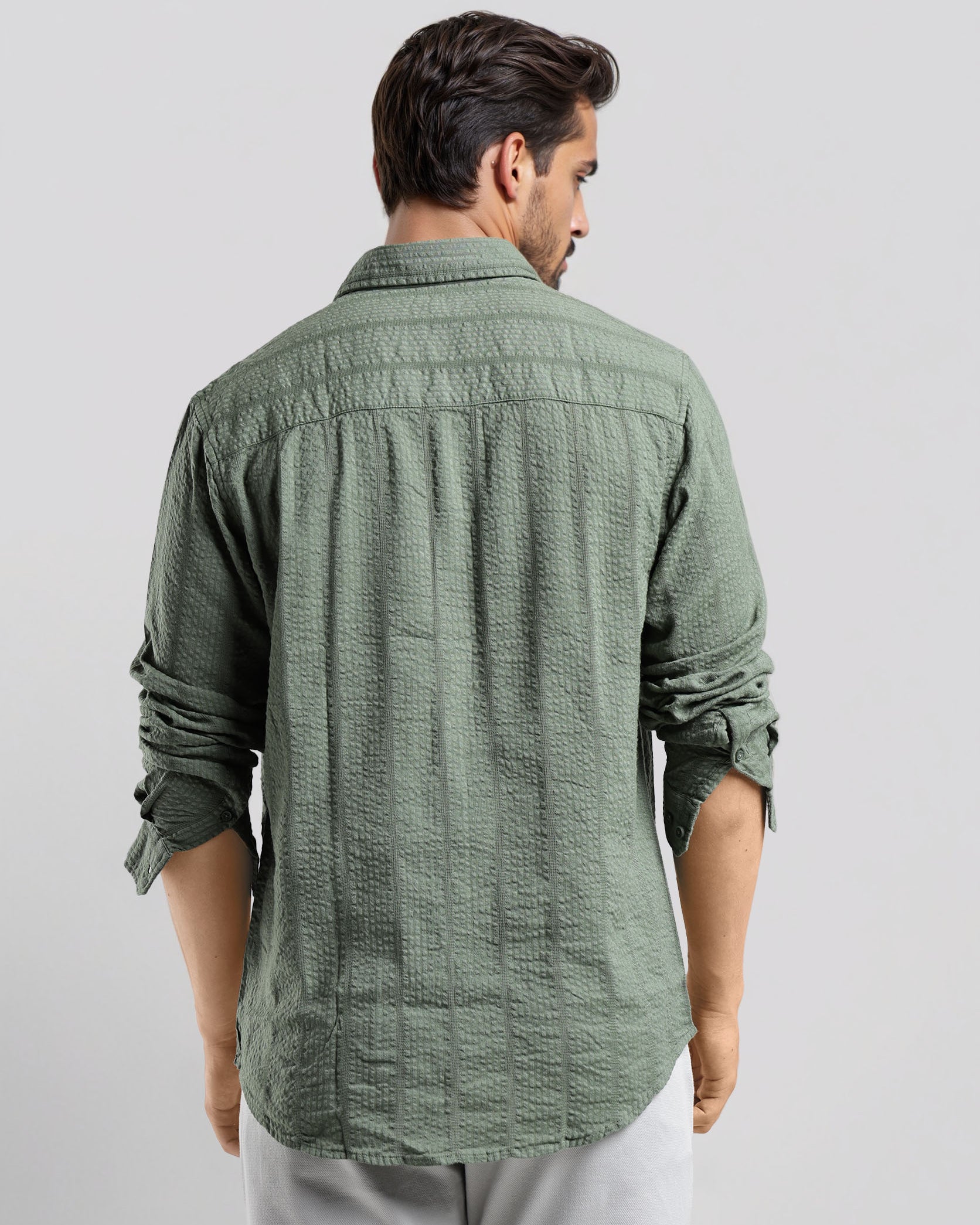 Man wearing a green textured shirt against a white background