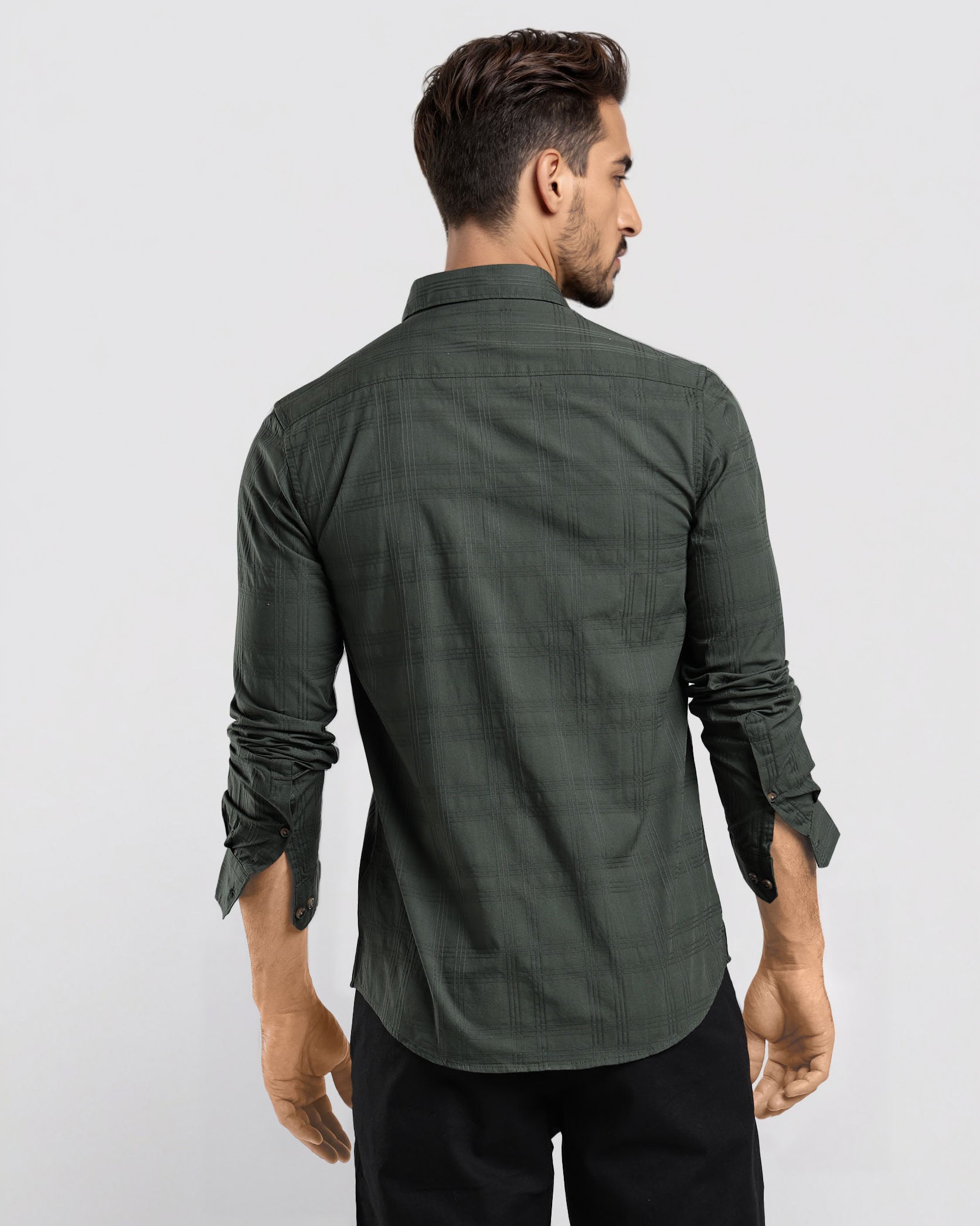 Man wearing a green shirt and black pants against a white background