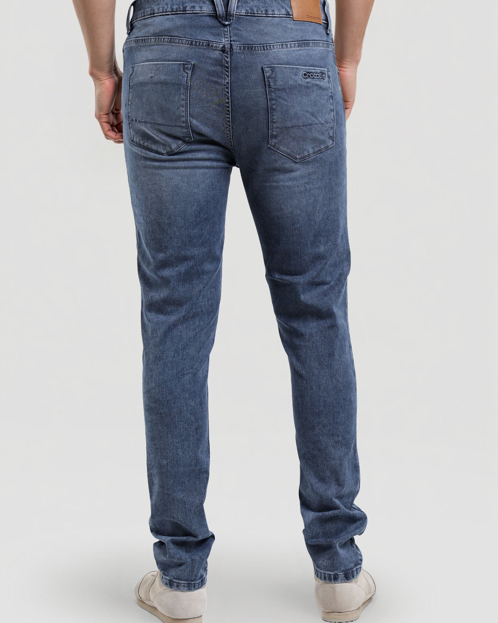 Person wearing blue jeans on a white background