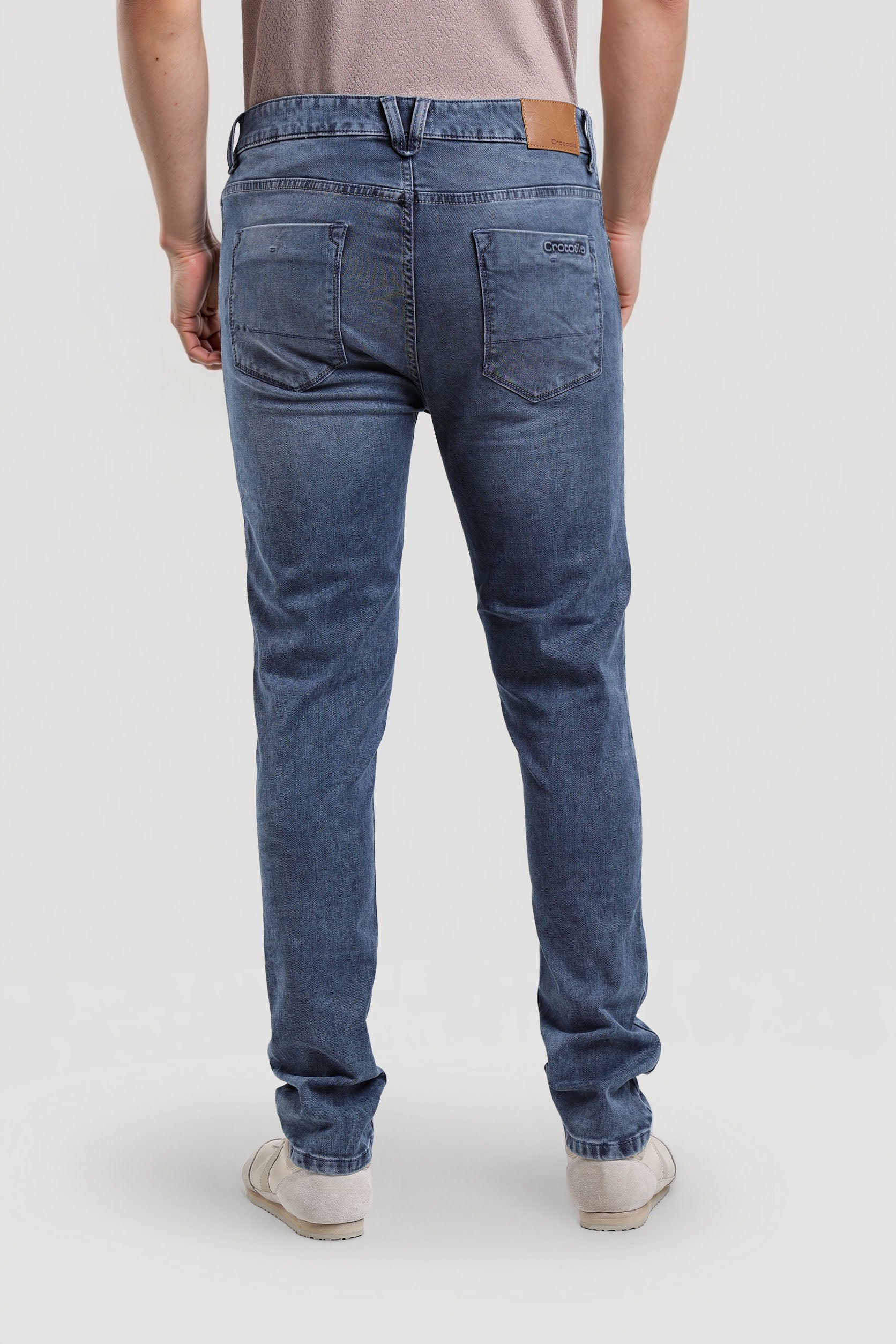 Person wearing blue jeans on a white background