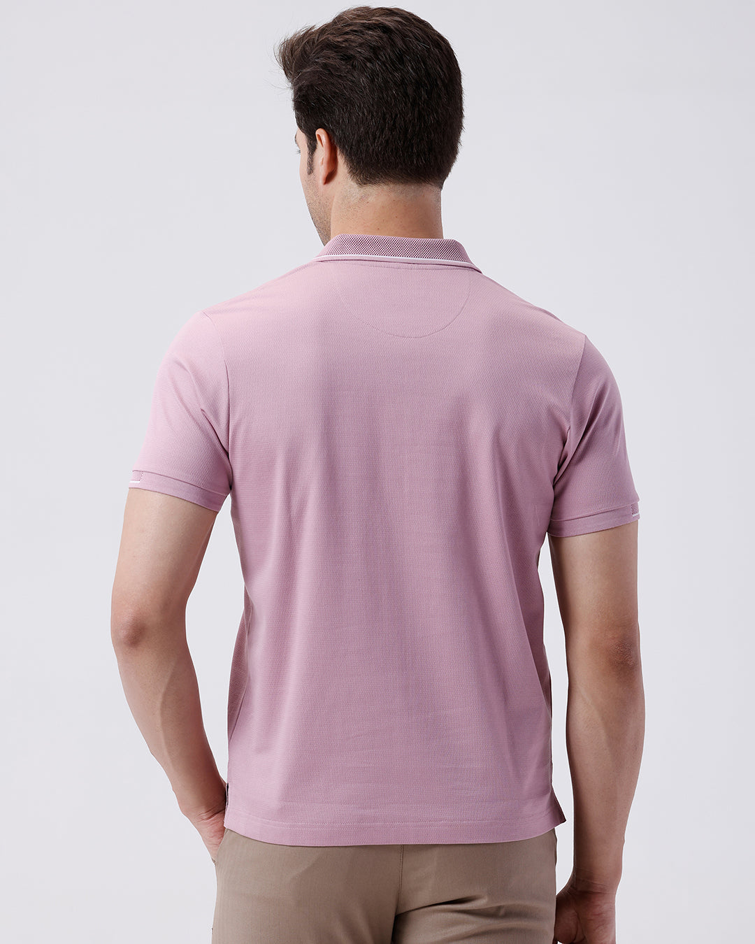 Man wearing a red mercerized subtle textured polo t shirt with casual styling on a gray background