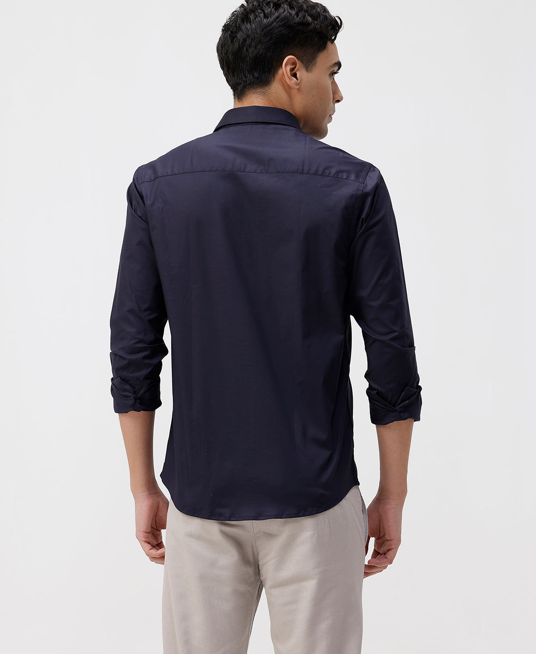 Man wearing a navy mercerized stretch shirt navy with casual styling on a gray background
