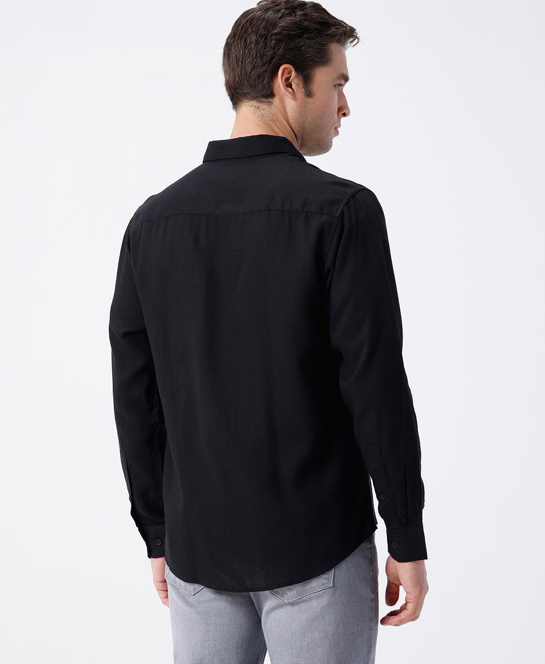 Man wearing a black linen blend shirt in black with casual styling on a gray background