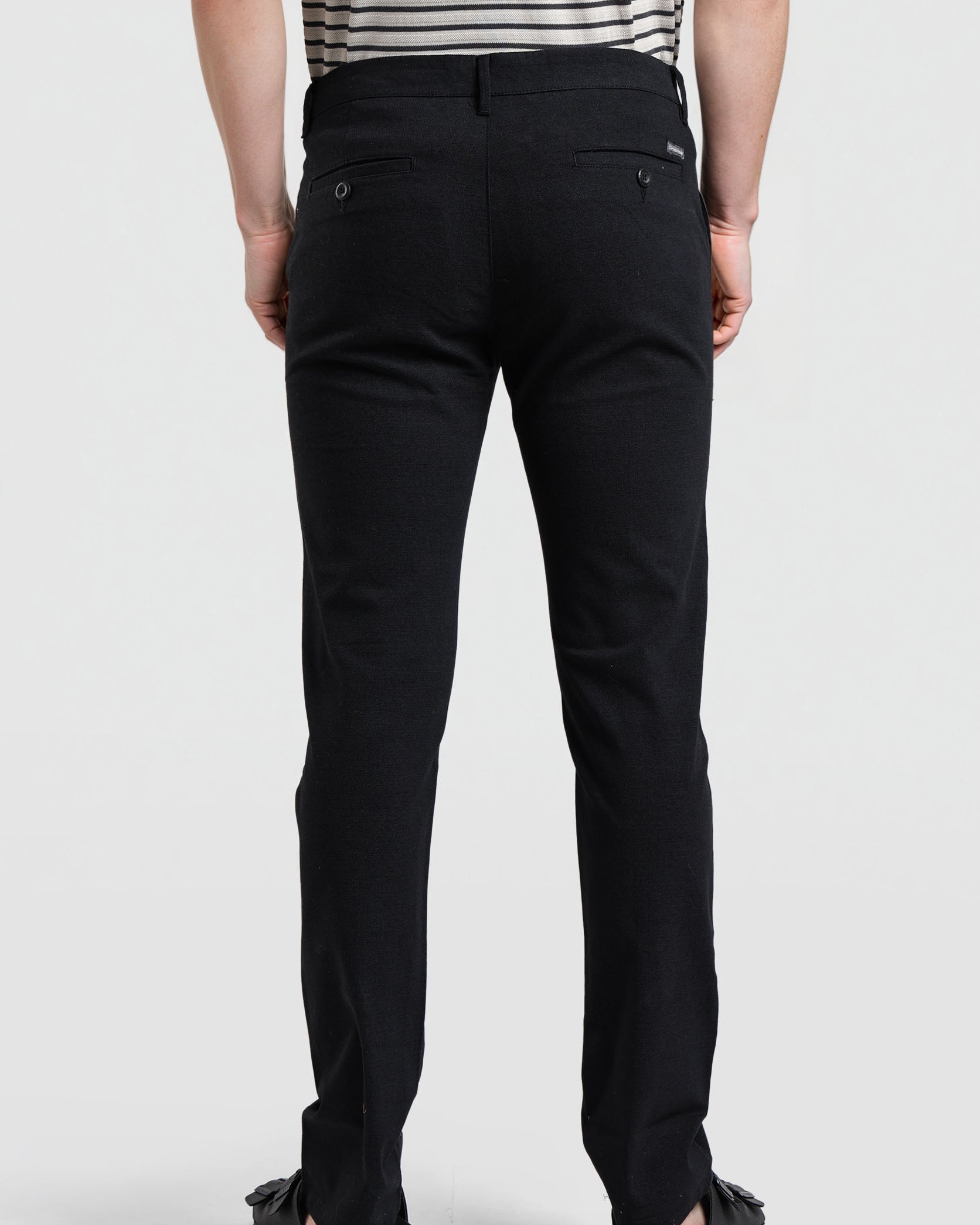 Person wearing black pants on a white background