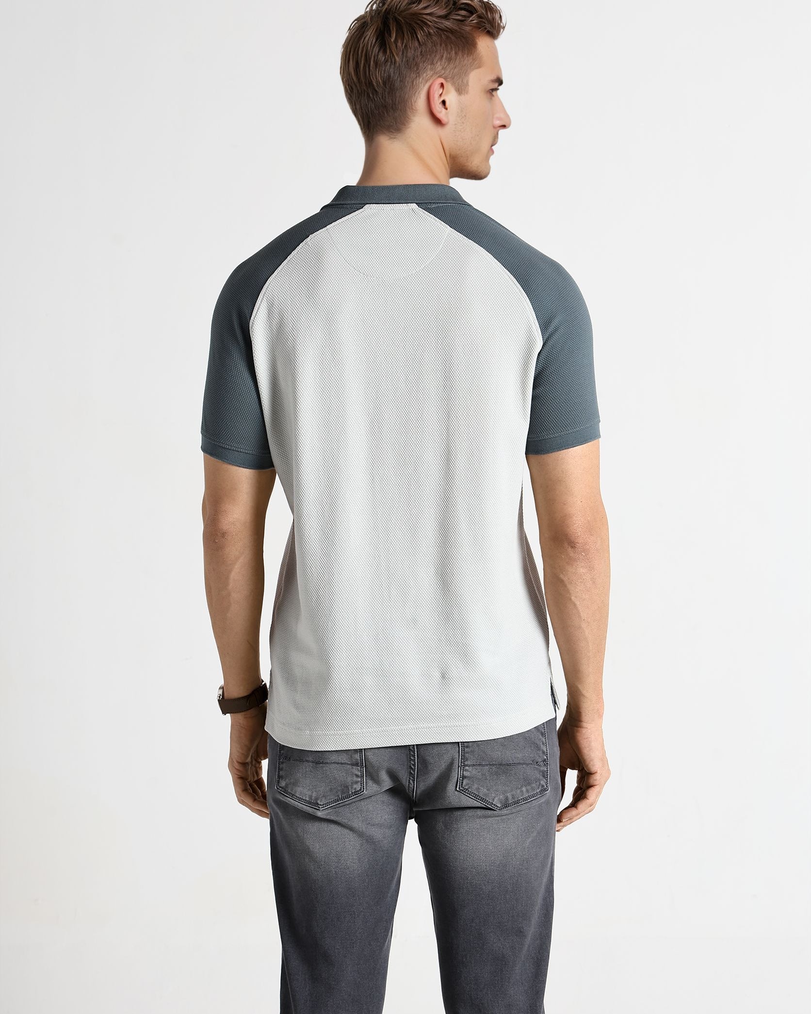 Man wearing a gray and white baseball-style shirt on a white background