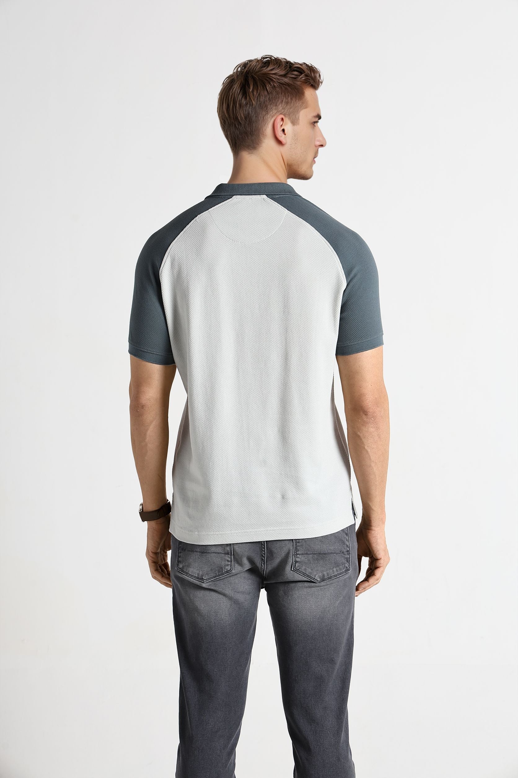 Man wearing a gray and white baseball-style shirt on a white background