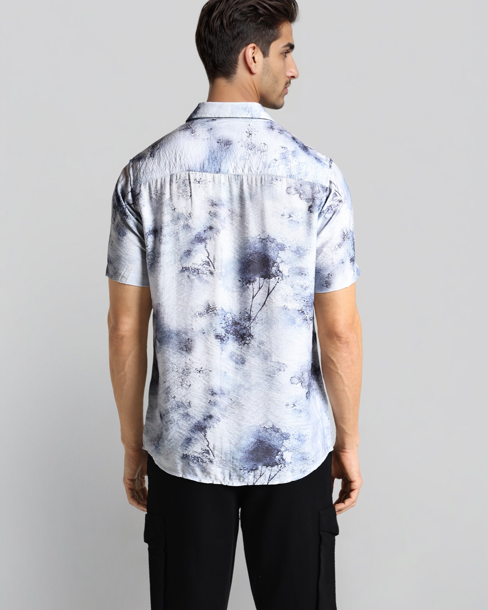 Man wearing a tie-dye shirt with a plain background