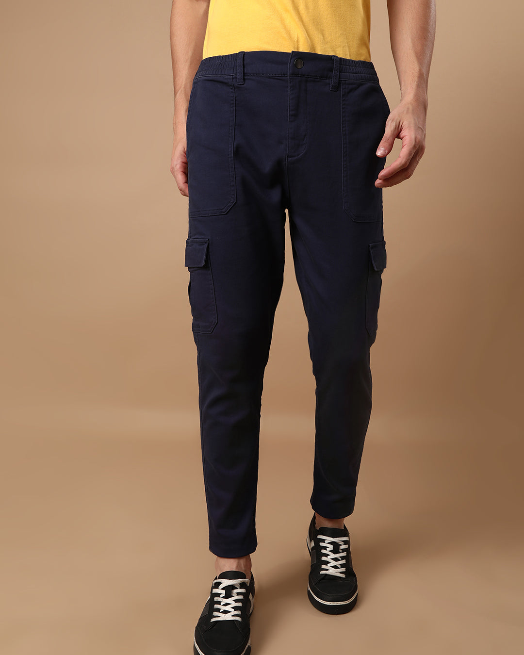 Man wearing a navy super soft navy cargo jogger with casual styling on a gray background