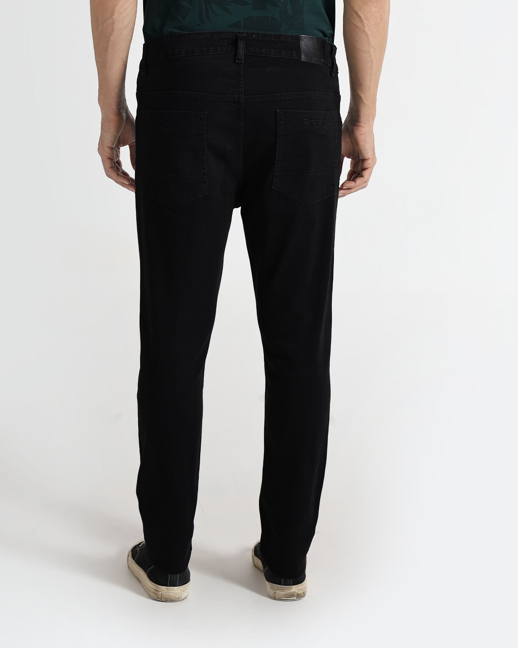 Person wearing black pants and a green shirt with white text on a white background