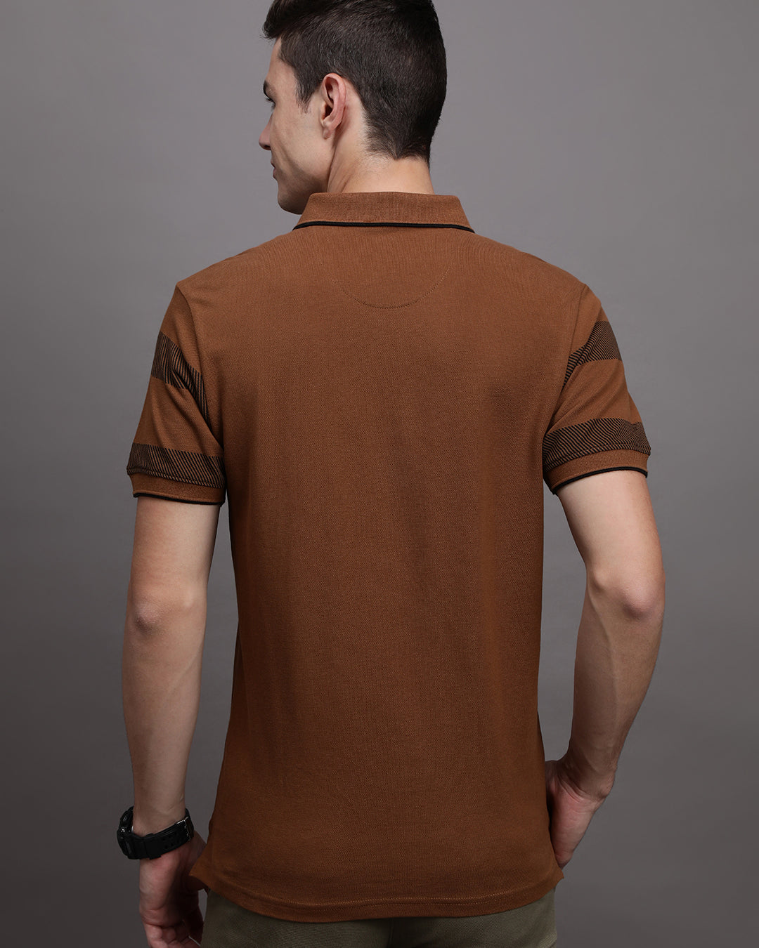 Man wearing a yellow rubber yellow printed polo t shirt with casual styling on a gray background