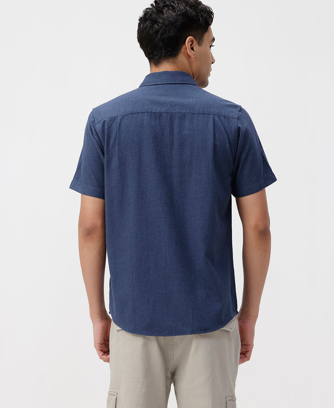 Man wearing a blue melange shirt solid blue on a light gray background