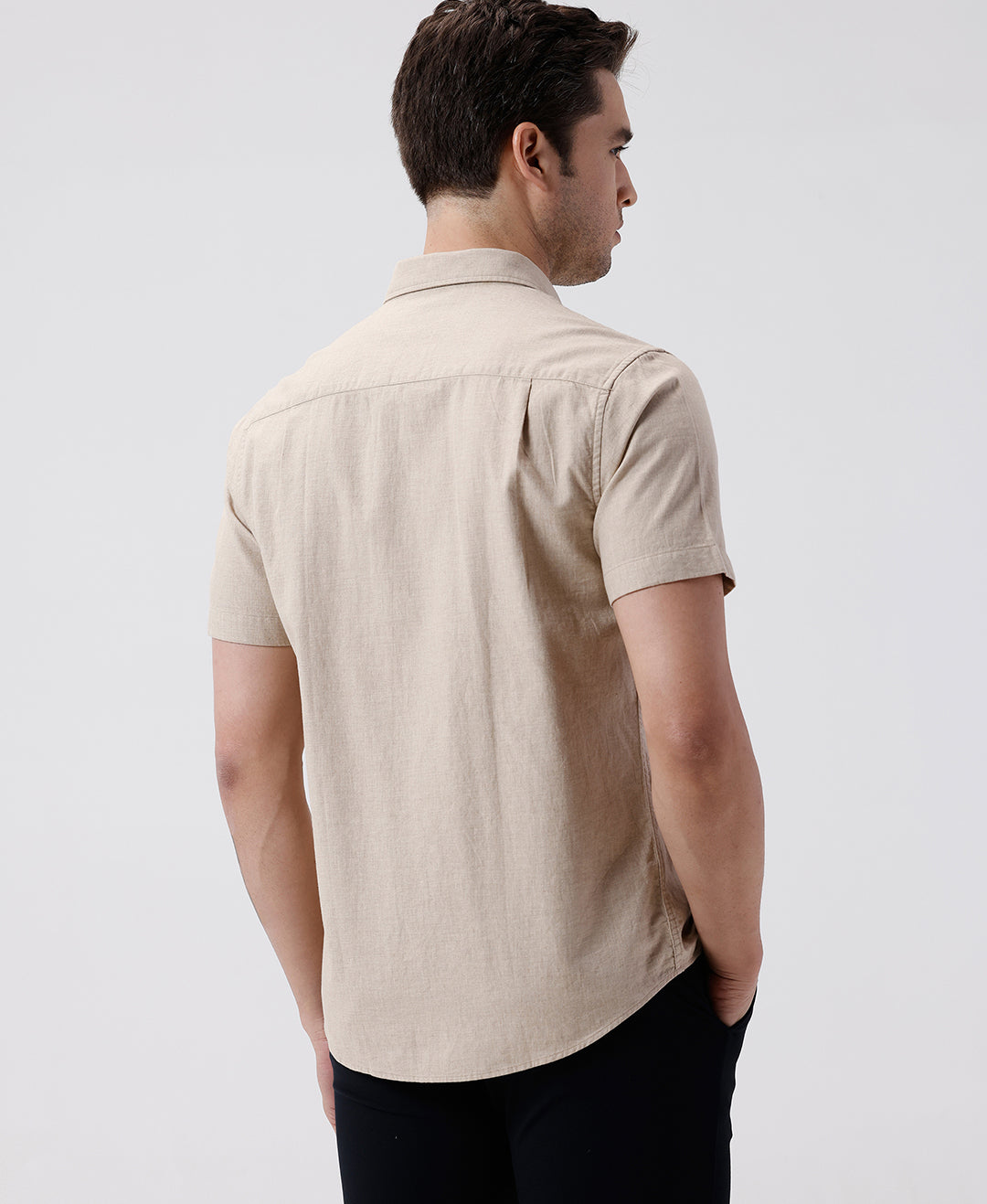 Man wearing a beige melange shirt solid beige on a light gray background