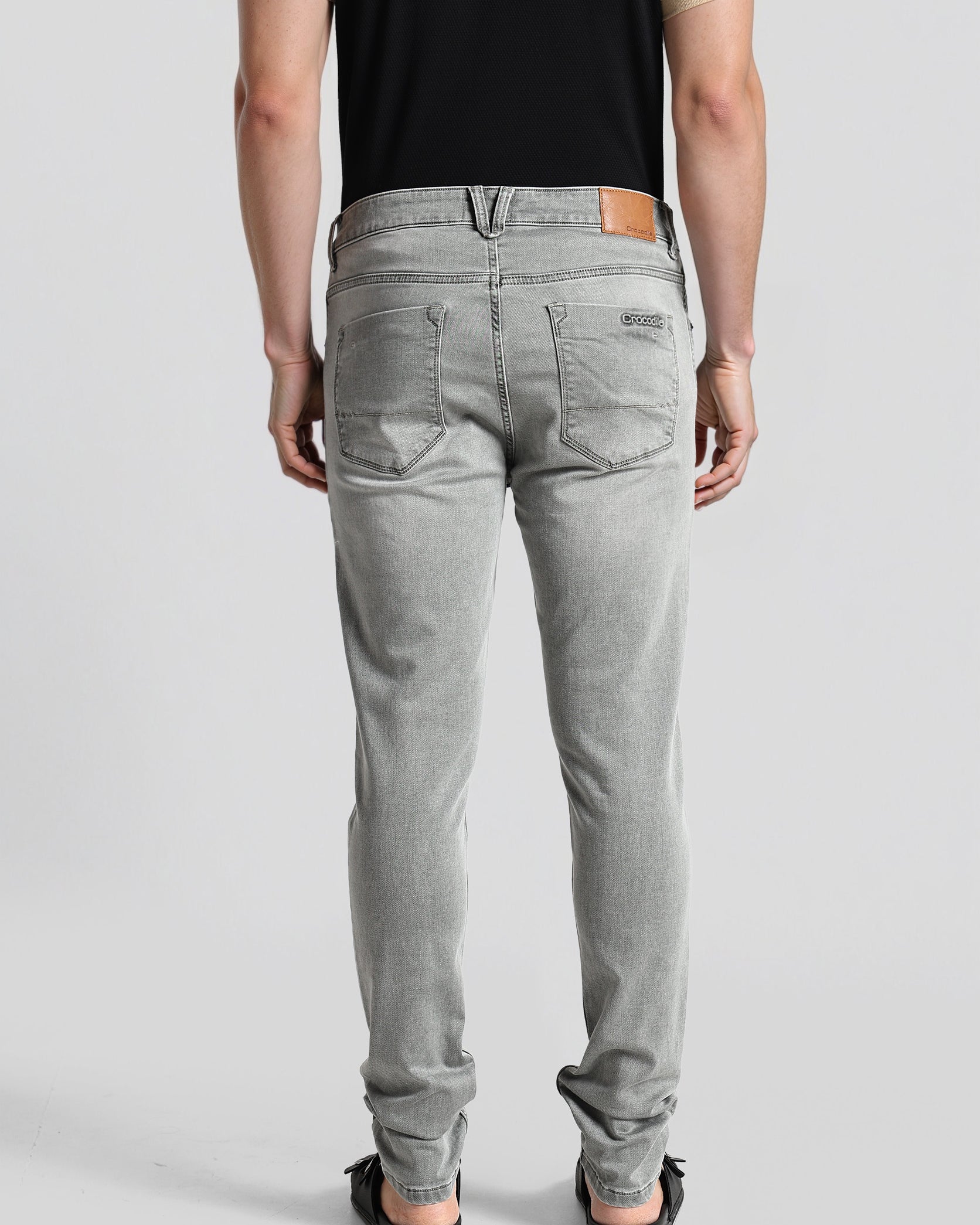 Person wearing gray jeans on a plain background