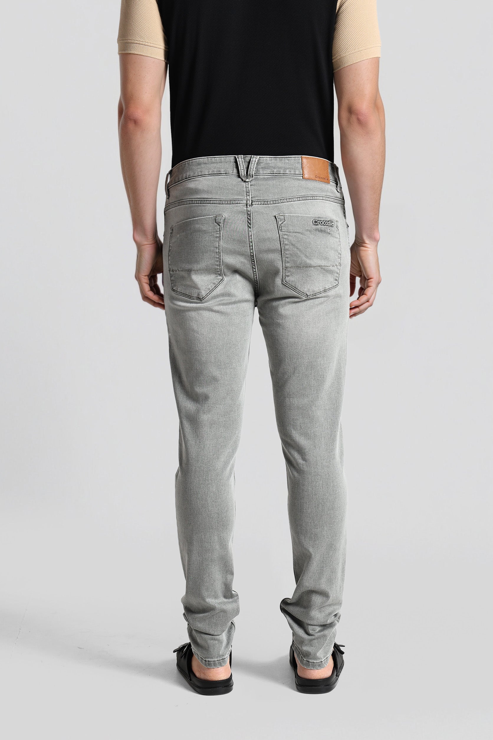 Person wearing gray jeans on a plain background
