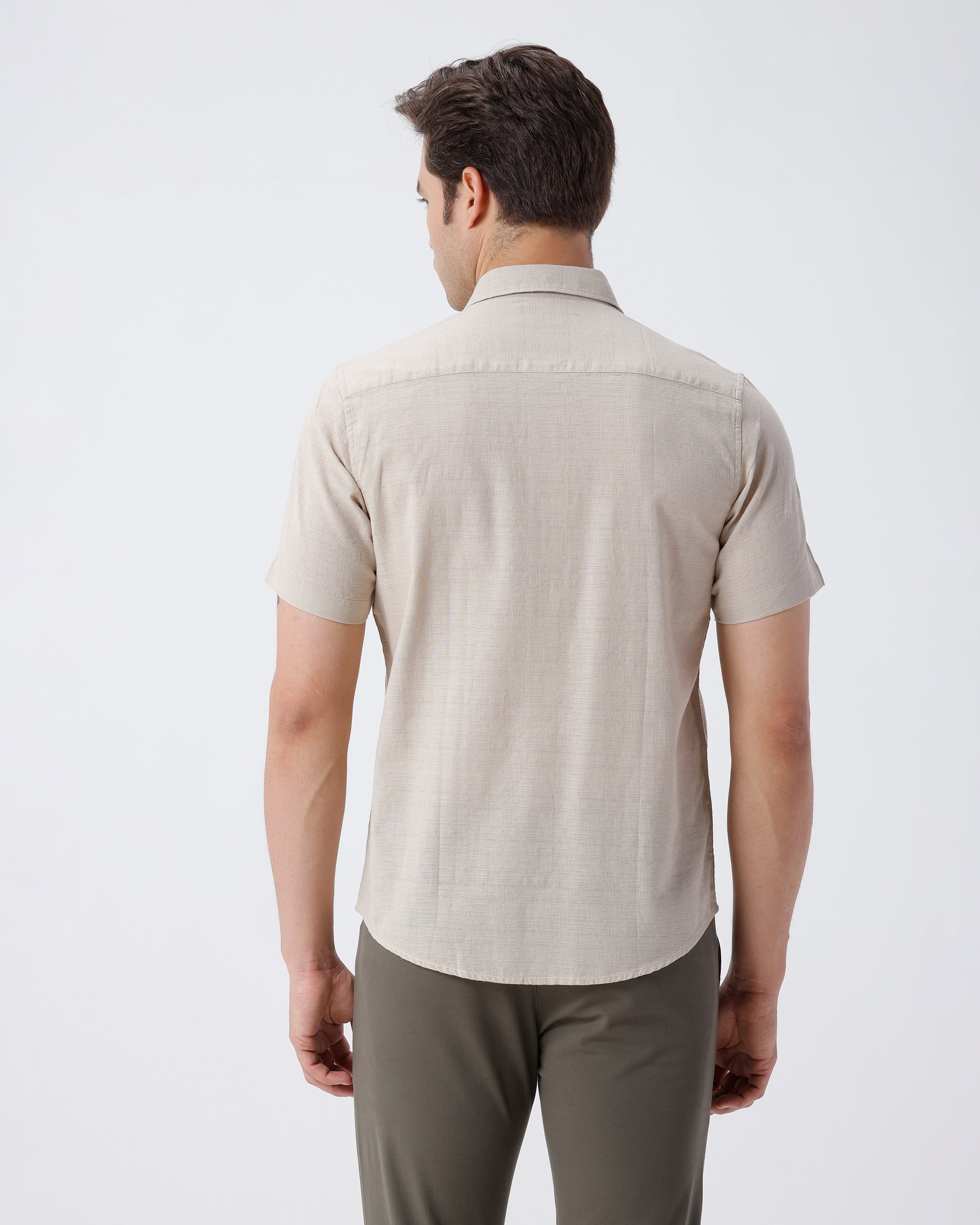 Man wearing a beige pure cotton textured shirt beige on a light gray background
