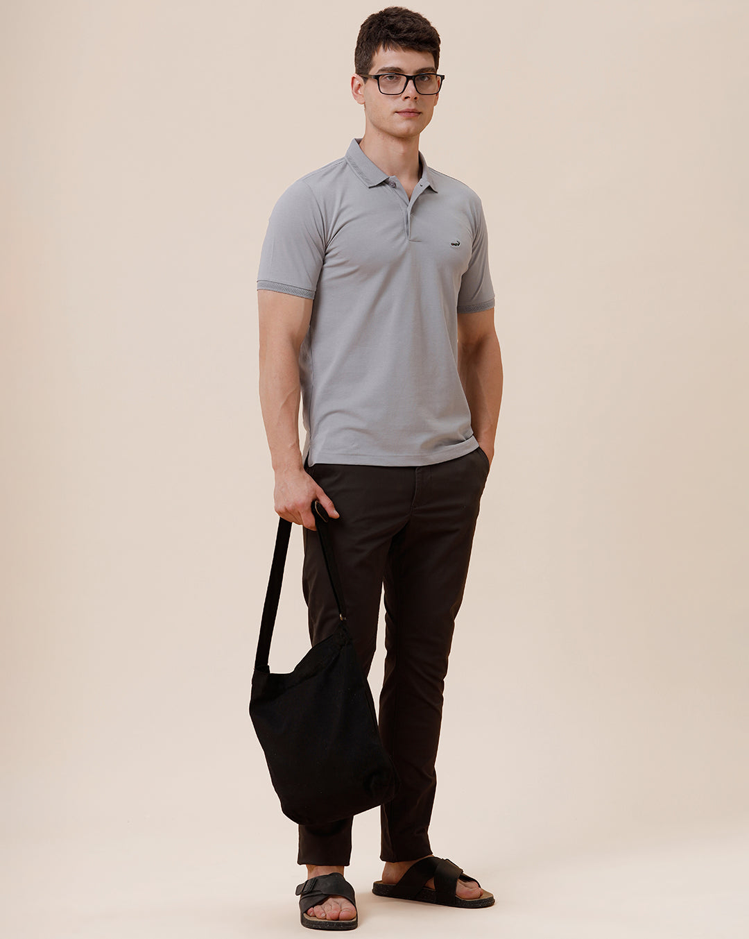 Man wearing a solid half sleeve casual polo t shirt on a light gray background
