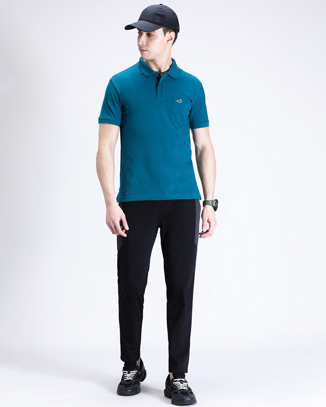 Man wearing a blue blue coral solid polo t shirt with casual styling on a gray background
