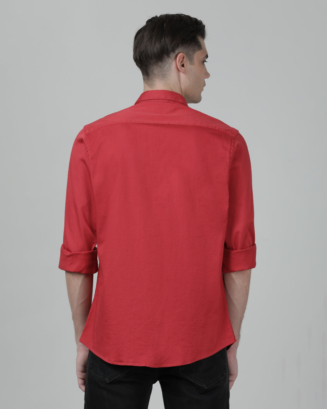 Man wearing a red tomato red solid full sleeve shirt on a light gray background