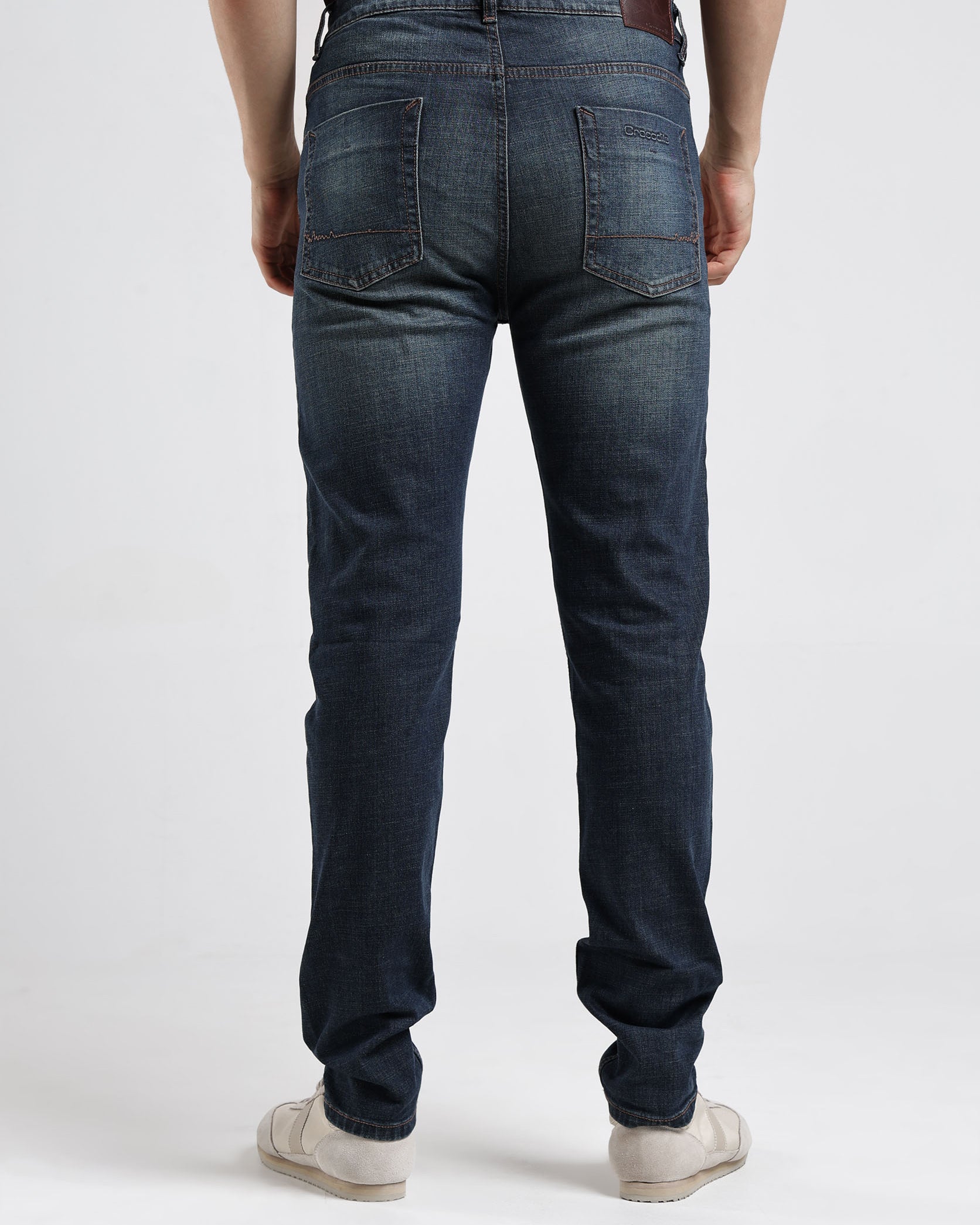 Person wearing blue jeans on a white background