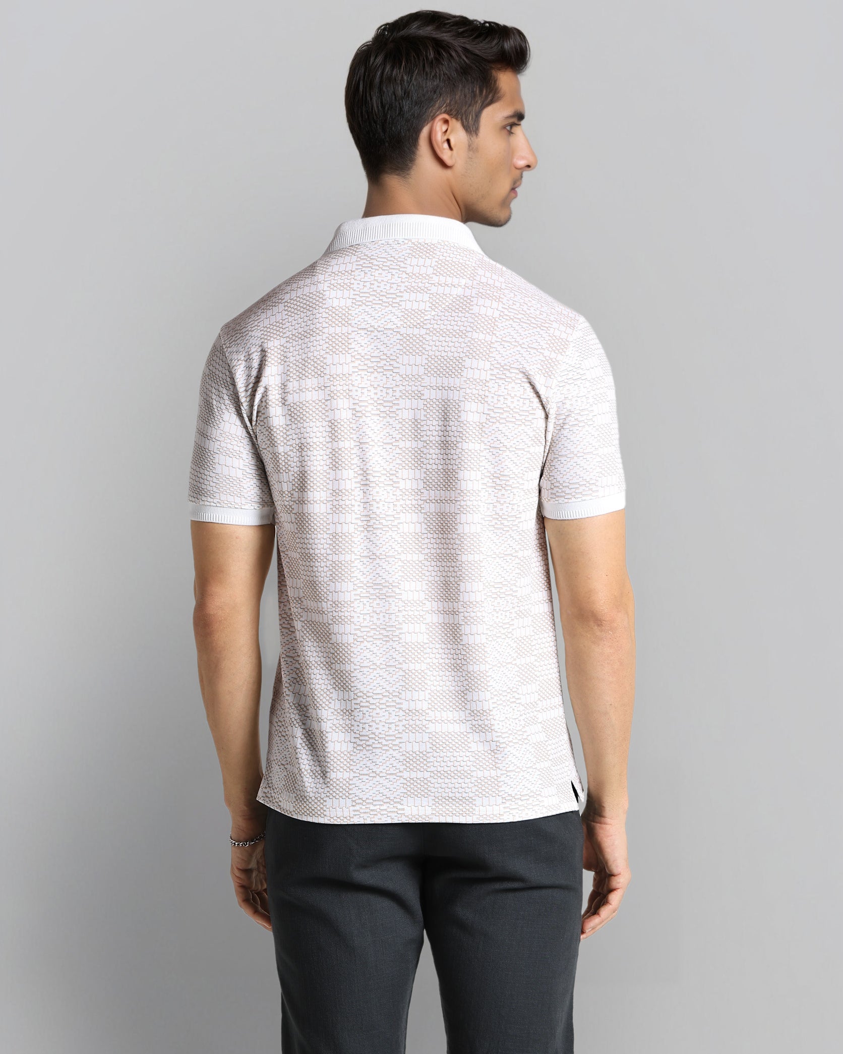 Man wearing a light gray polo shirt and black shorts on a gray background