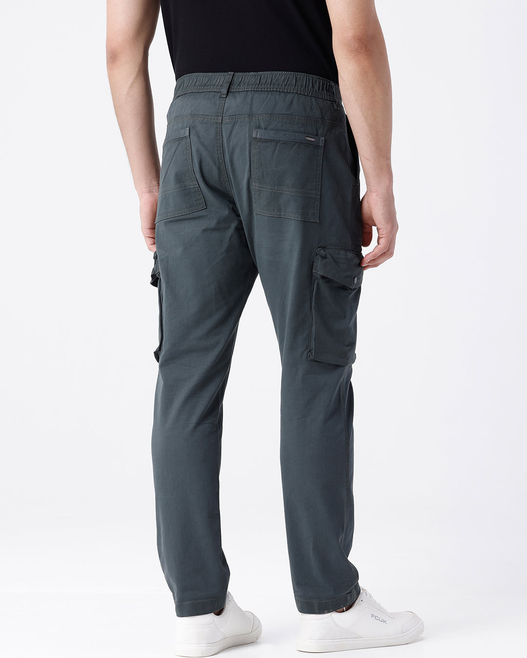 Man wearing a olive garment dyed cargo pant in olive with casual styling on a gray background