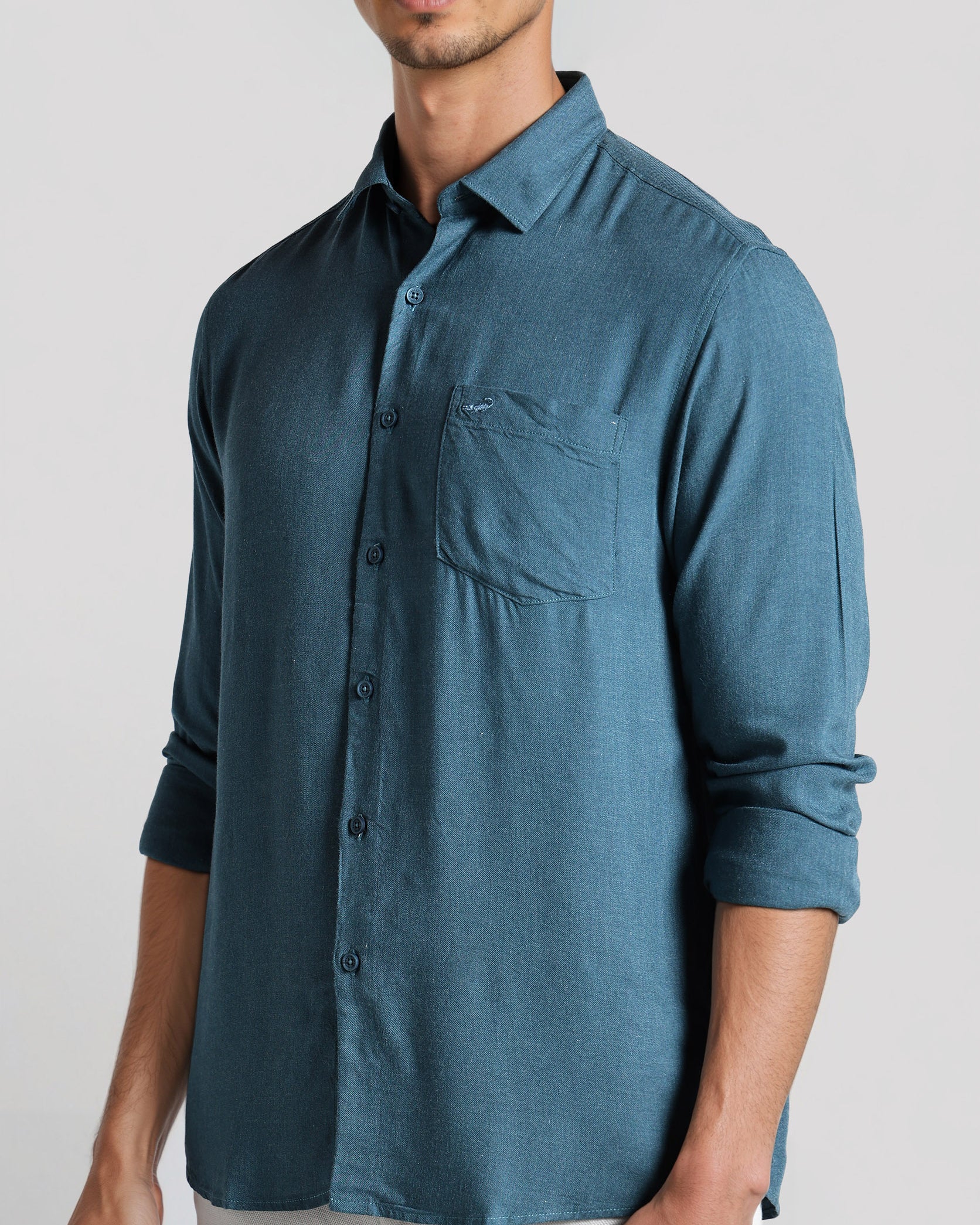 Man wearing a blue button-up shirt on a white background