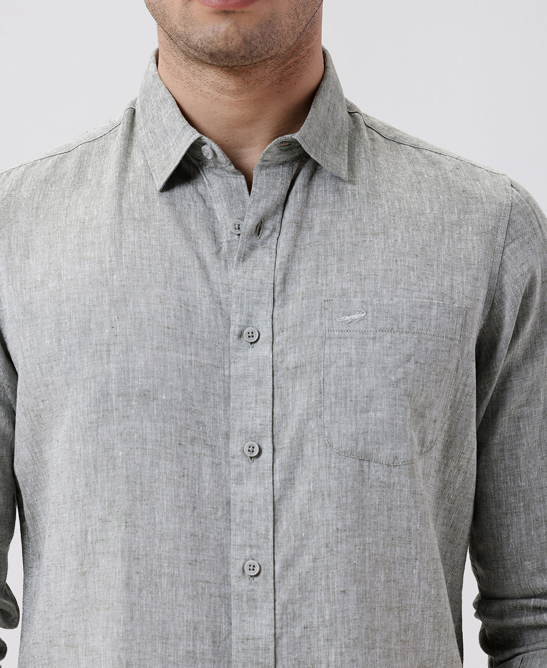 Man wearing a green premium tensil linen shirt dark green on a light gray background