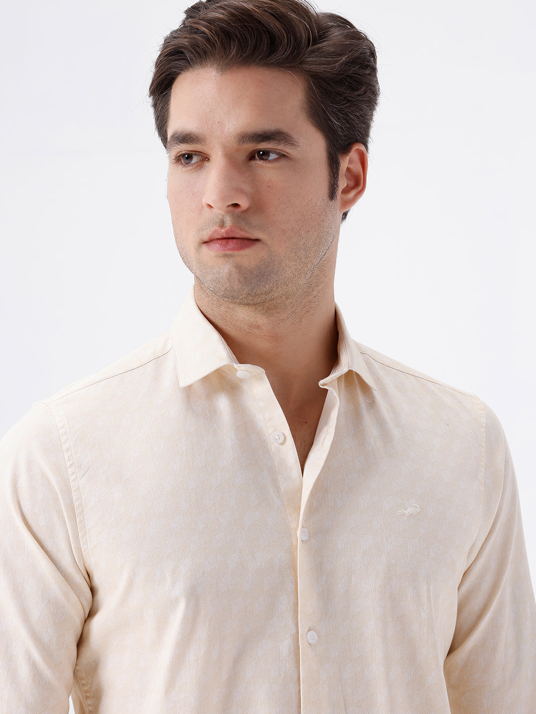 Man wearing a geomentic diamond print shirt on a light gray background