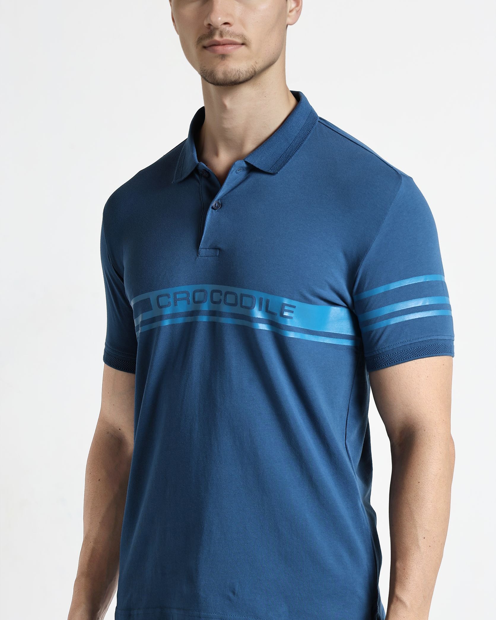 Man wearing a blue polo shirt with a brand logo on a white background