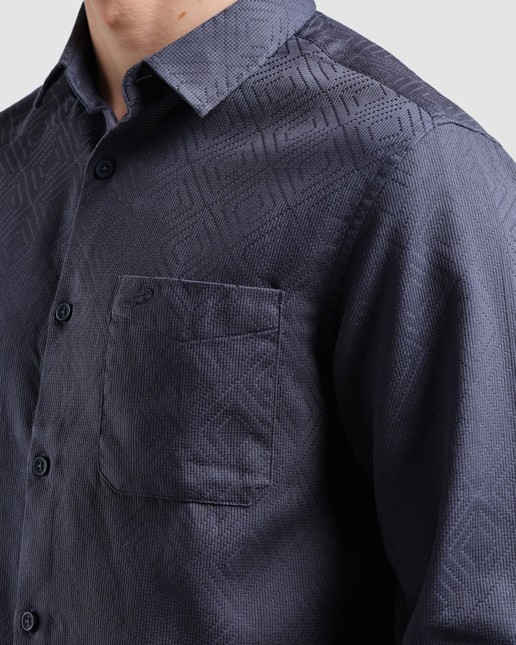 Navy patterned shirt worn by a person on a light gray background