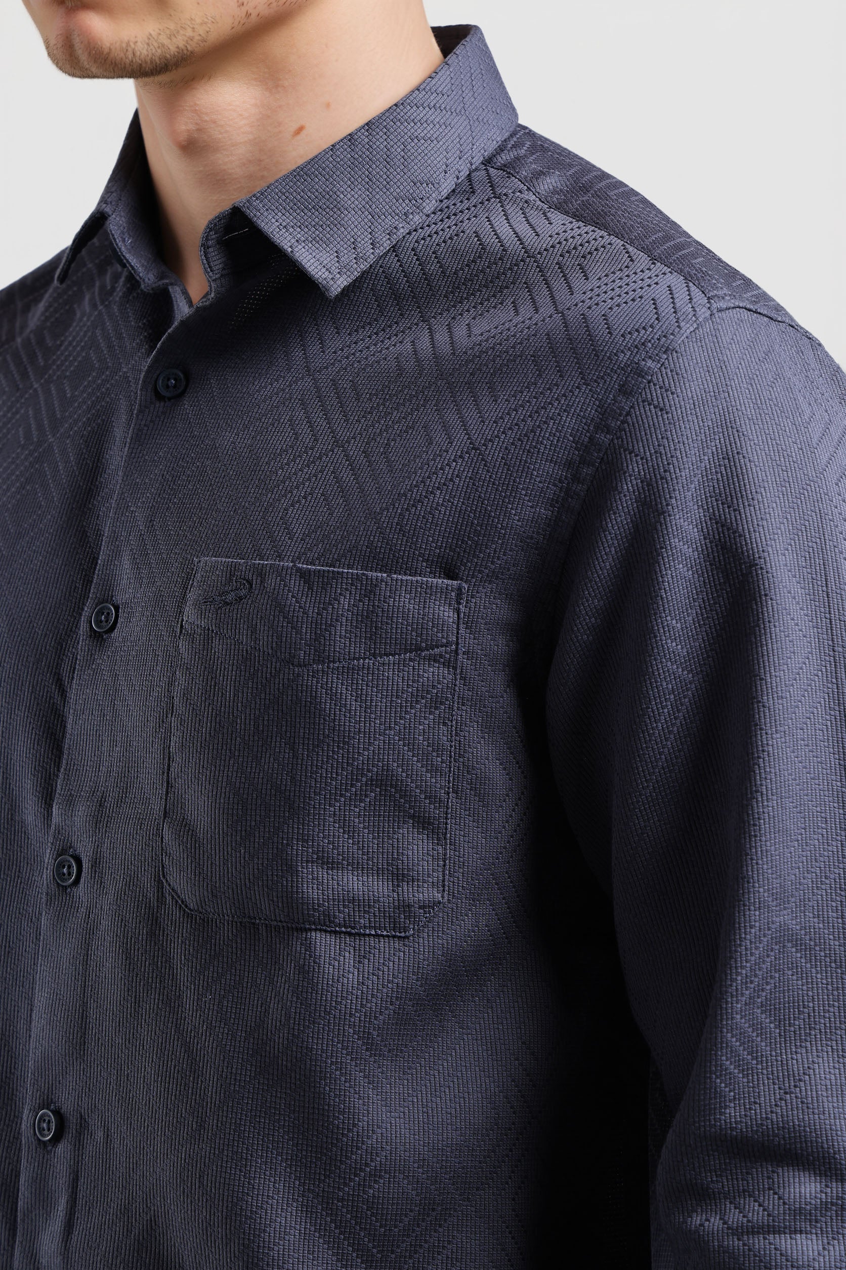 Navy patterned shirt worn by a person on a light gray background