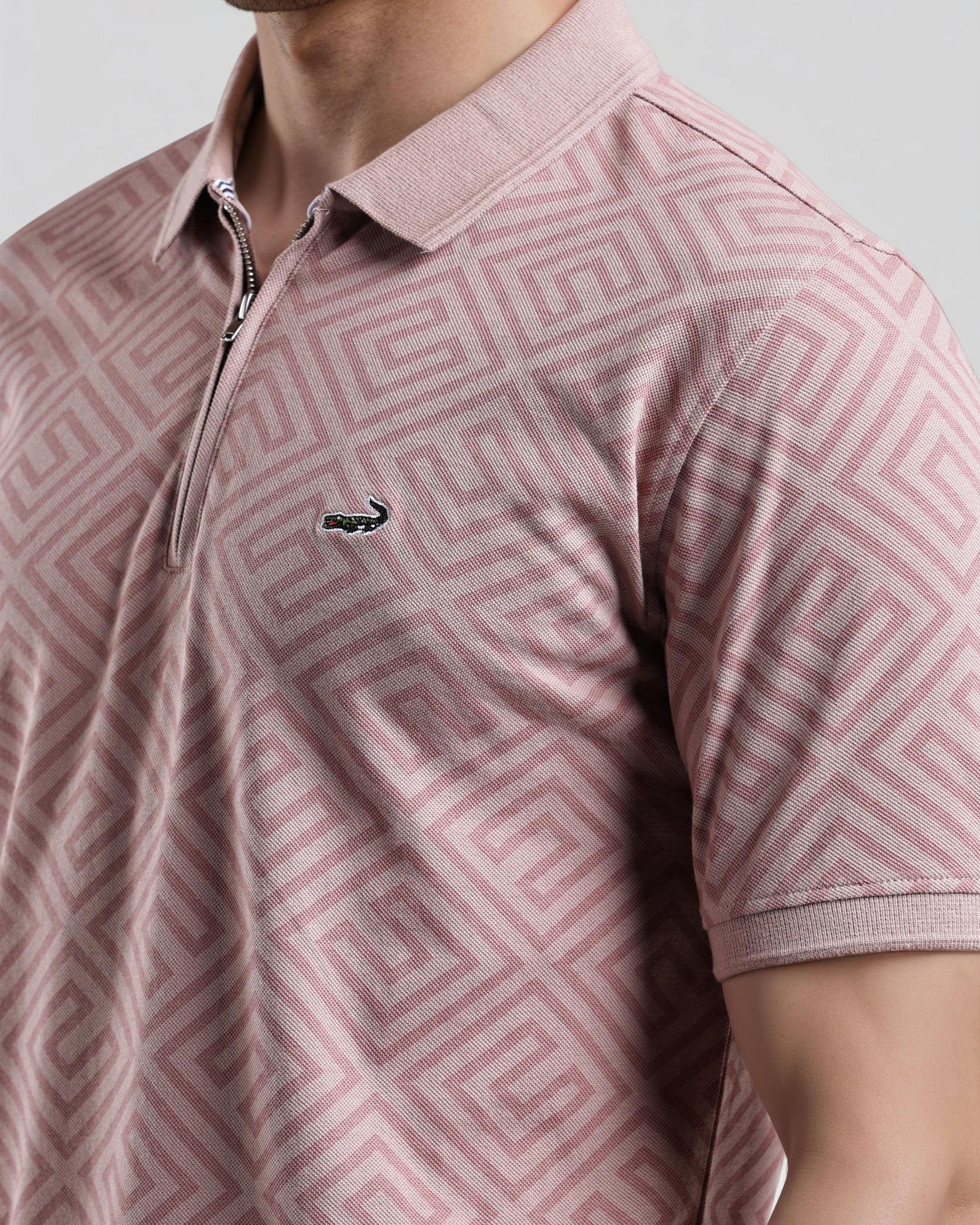 Pink patterned polo shirt with a small logo on a plain background