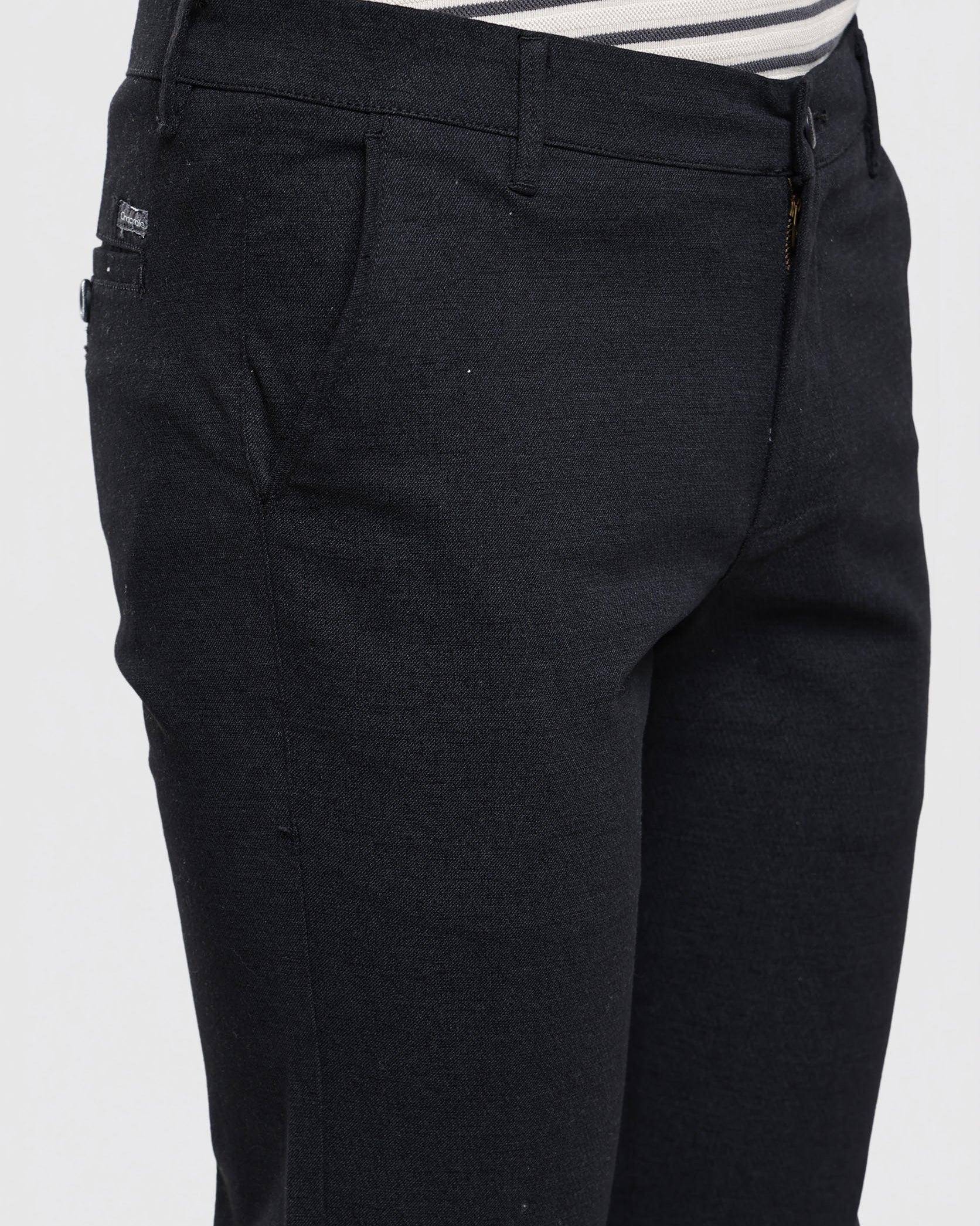 Black pants worn with a striped shirt on a white background