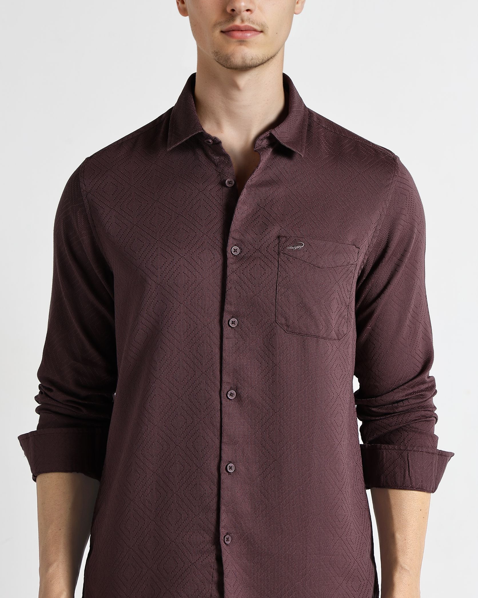 Man wearing a maroon button-up shirt on a white background