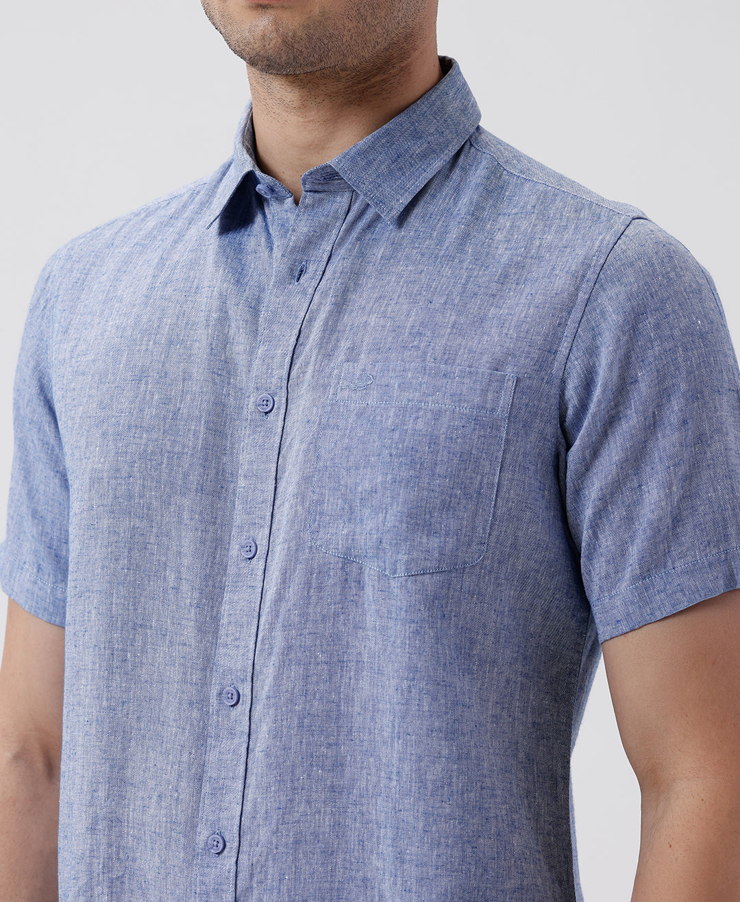 Man wearing a blue premium tensil linen shirt blue on a light gray background