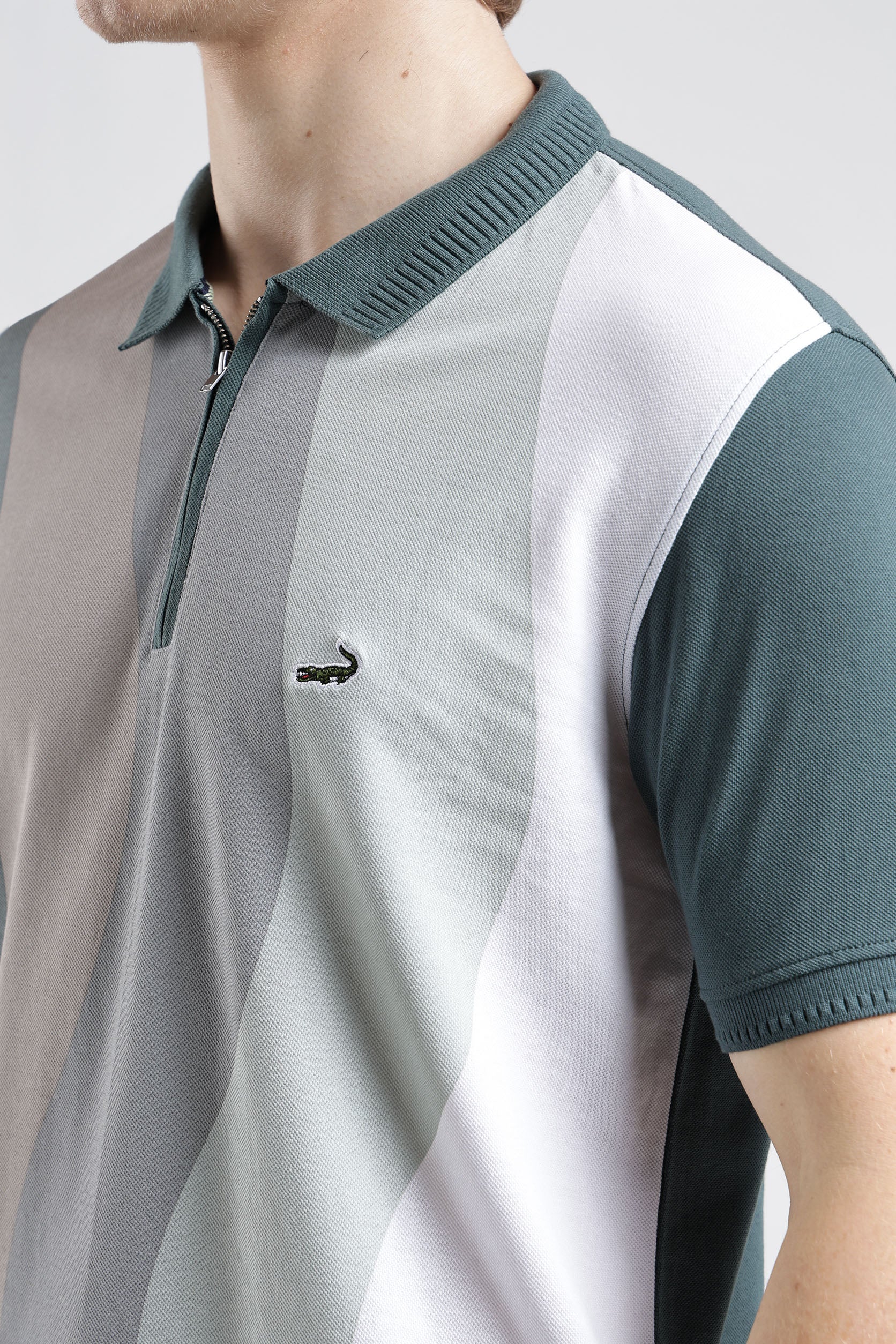 Color-blocked polo shirt with a brand logo on a neutral background