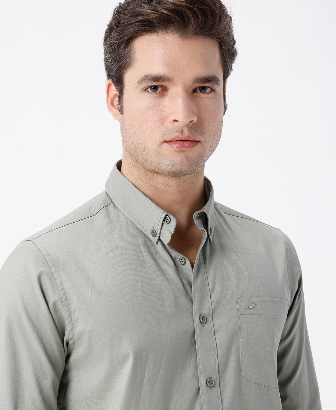Man wearing a green smart series premium oxford shirt green with casual styling on a gray background