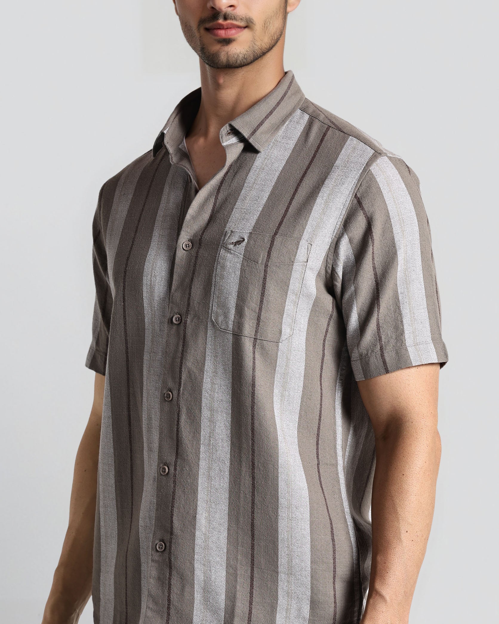 Man wearing a striped shirt with a plain background