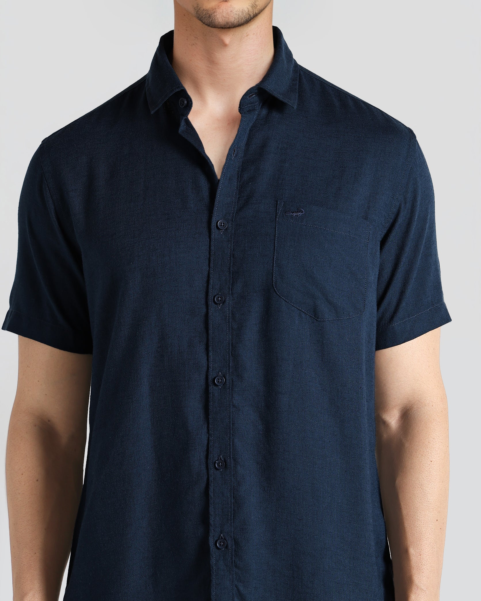 Man wearing a navy blue short-sleeve shirt on a white background