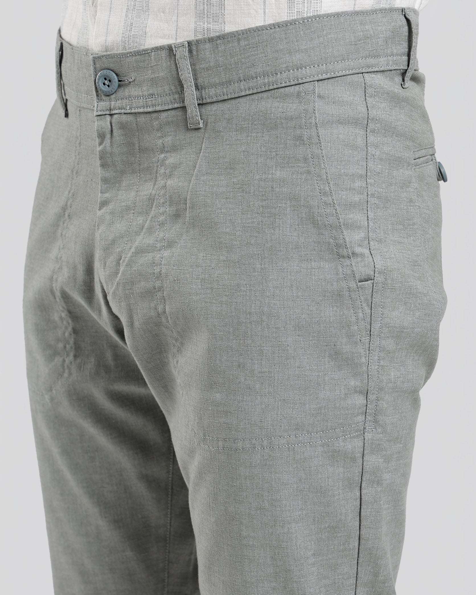 Gray pants worn with a white shirt on a plain background