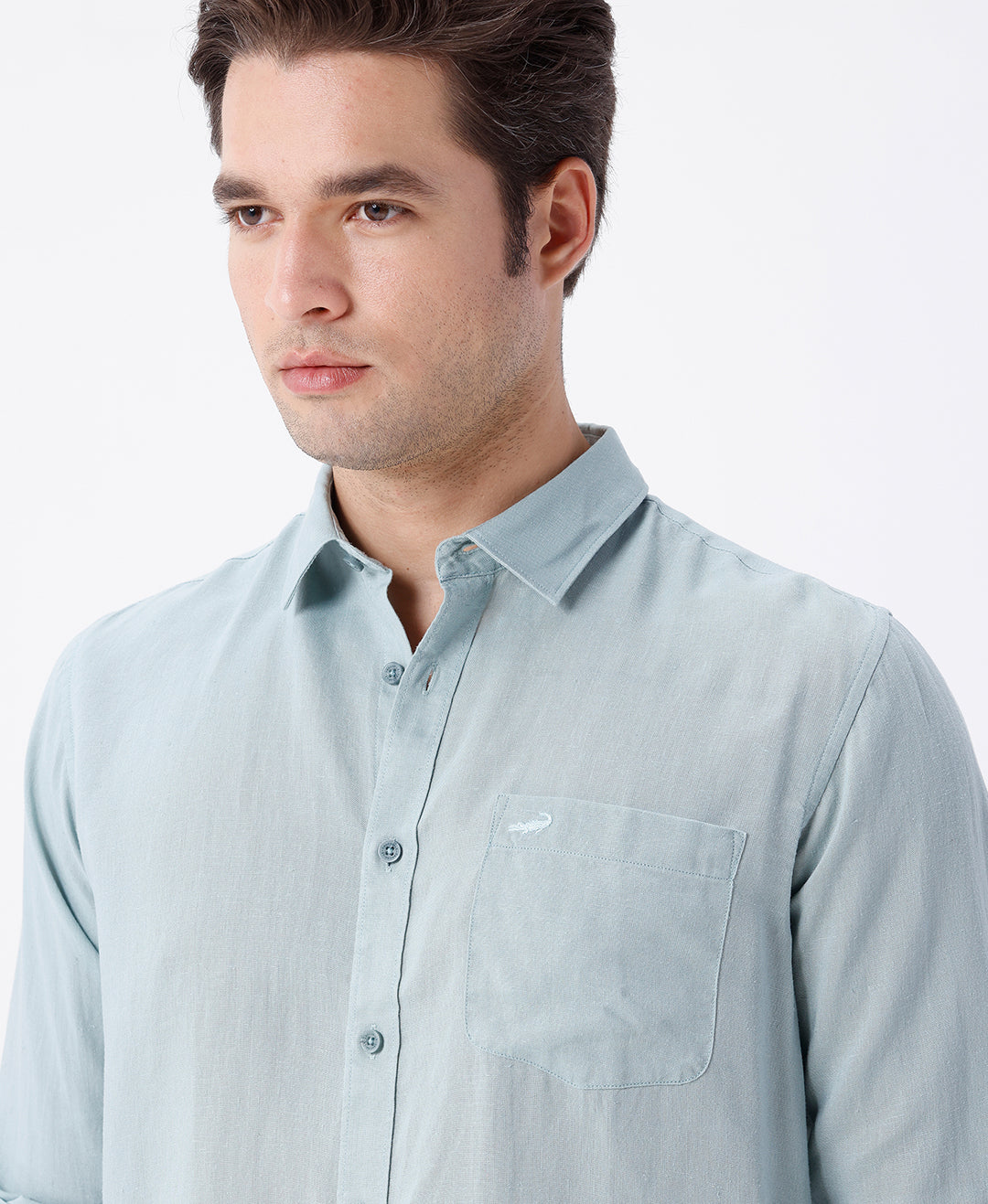 Man wearing a green linen blend shirt in green on a light gray background
