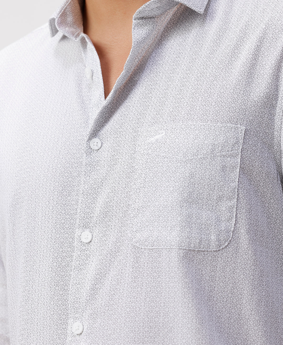 Man wearing a white white all over print slim fit casuals shirts with casual styling on a gray background