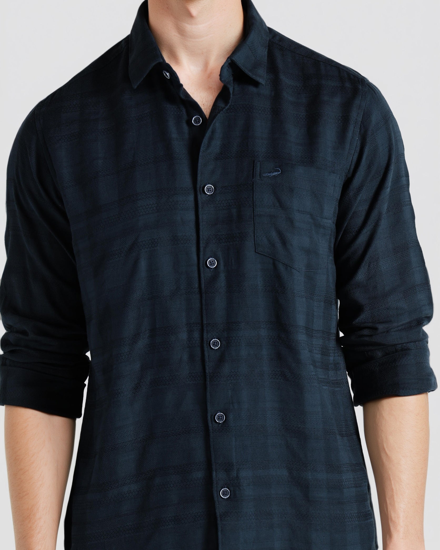 Man wearing a dark blue button-up shirt against a white background