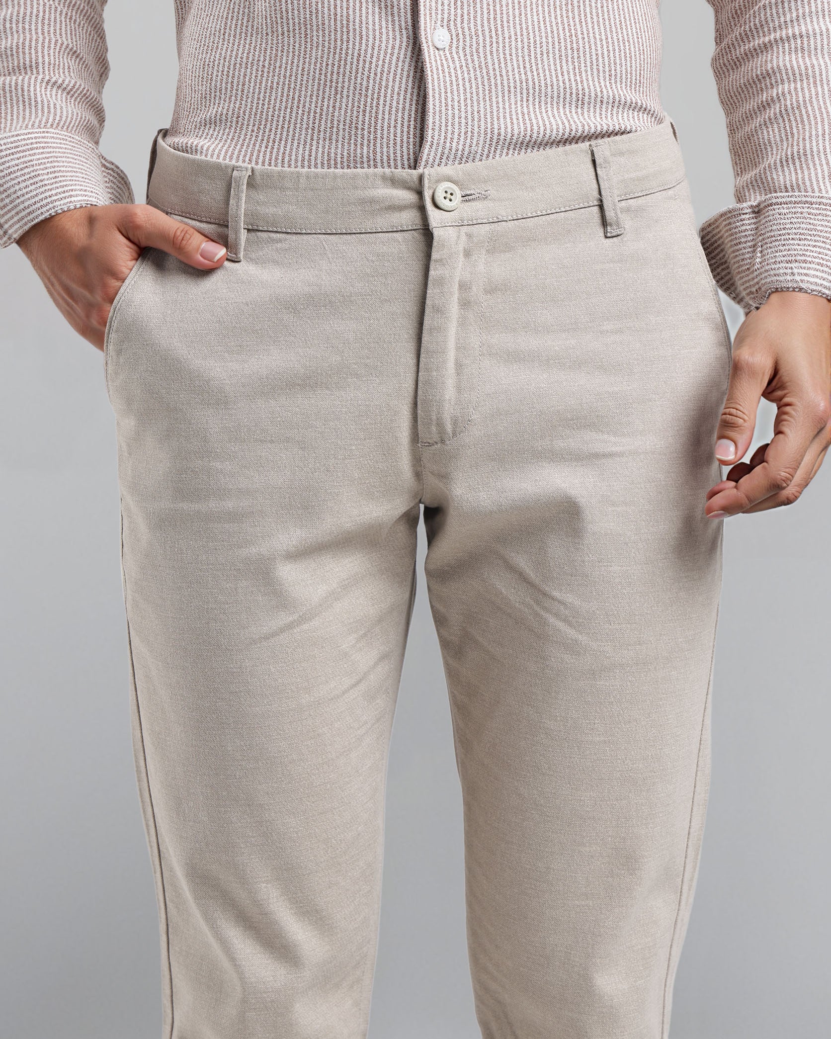 Beige pants worn by a person on a gray background